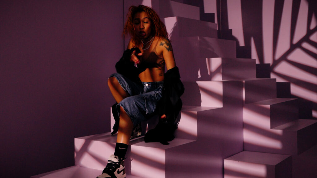 Behind the scenes filming of artist performance on stylized set with dramatic lighting