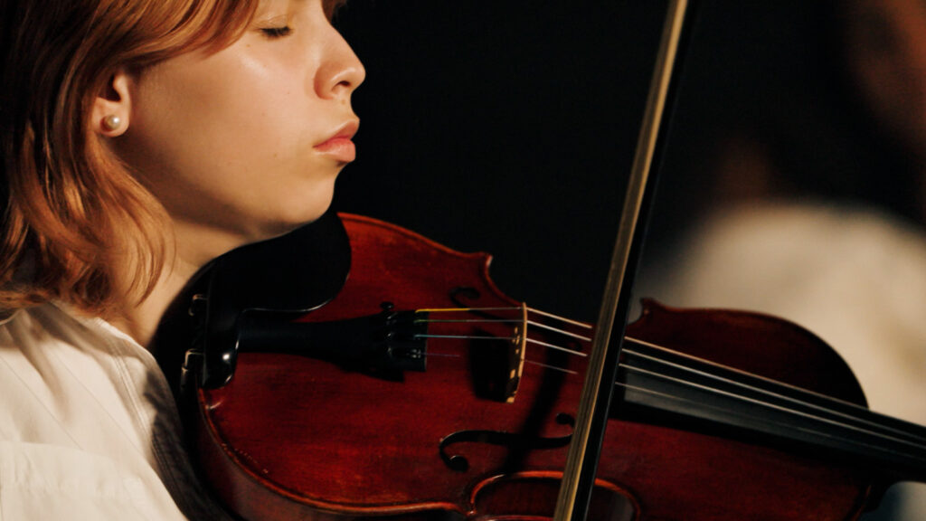 Close up of violinist performing during cinematic music video production