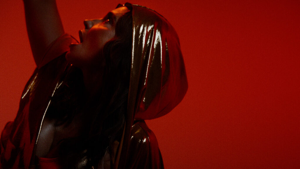 Cinematic video thumbnail of performer under dramatic red lighting