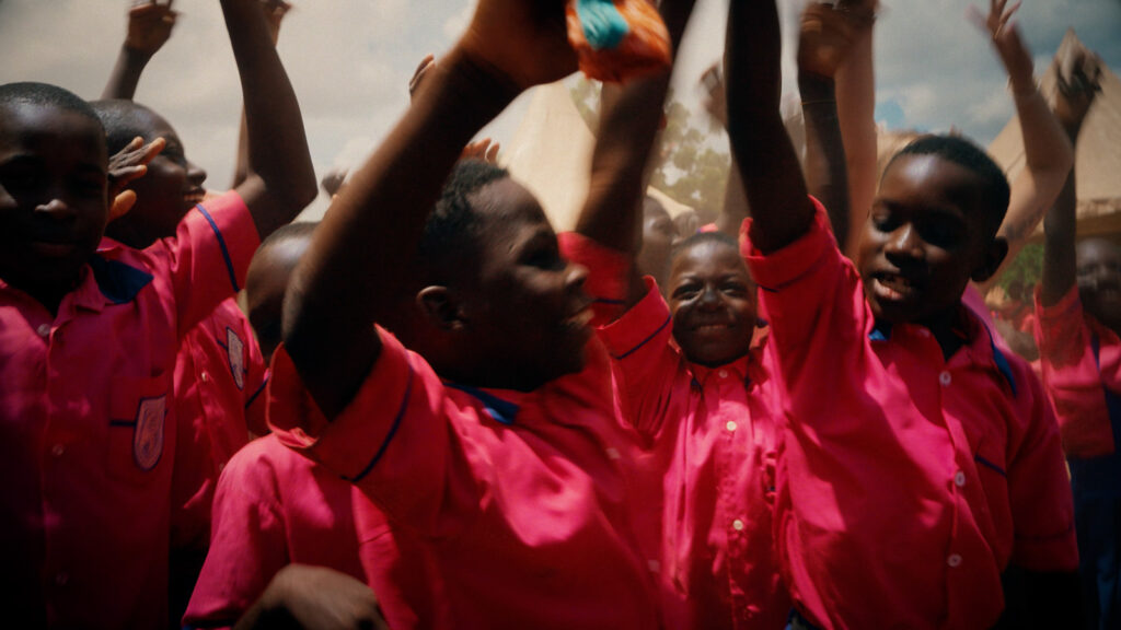 Cinematic shot of children celebrating together outdoors in bright clothing, filmed by Hiatt Films