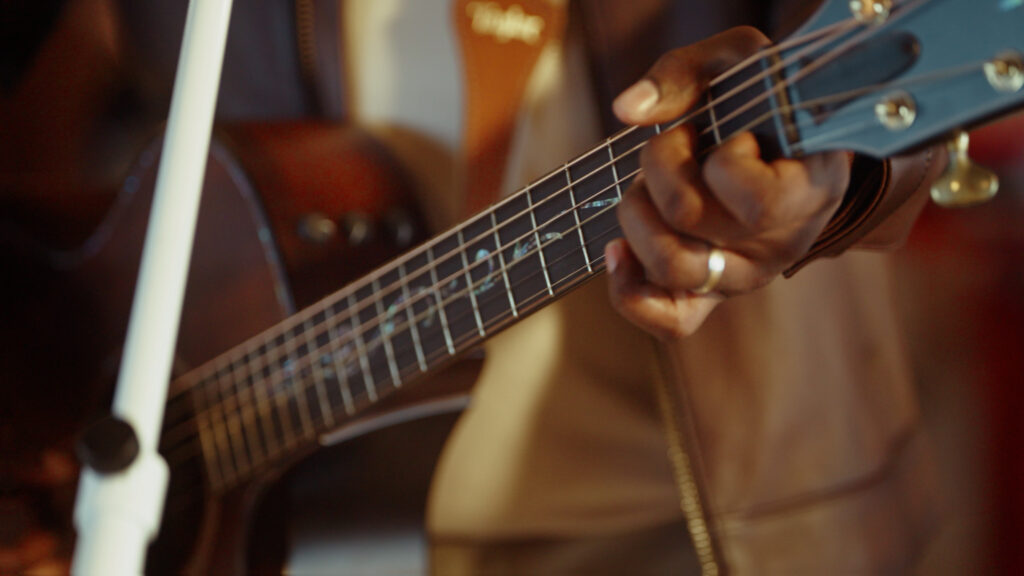 Close-up of musician playing acoustic guitar with shallow depth of field