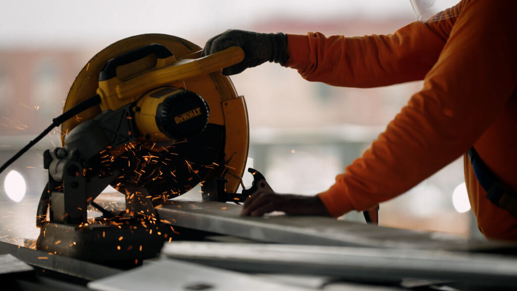 Worker using circular saw cutting material with sparks flying